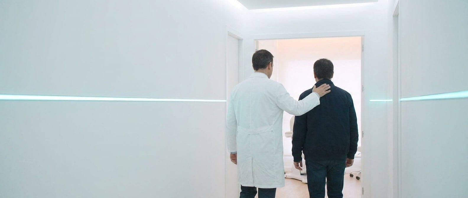 Klinik koridorunda doktor, hastasına omzundaki eliyle eşlik ediyor